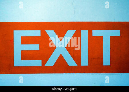 Das Wort "EXIT" geschrieben auf einer weißen Wand mit orange Umgebung Stockfoto
