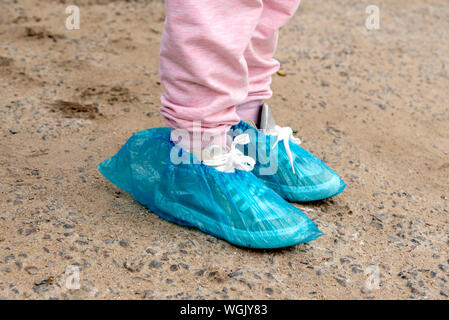 Blau medizinische Überschuhe Schuhe zu schützen. Beine in Überziehschuhe für ein Mädchen gekleidet Stockfoto