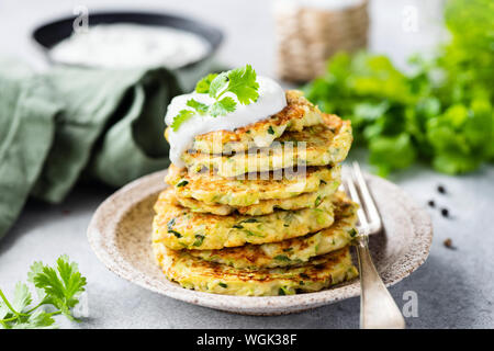 Gemüse zucchini Krapfen in mit saurer Sahne garniert. Gesunde vegetarische Kost Stockfoto