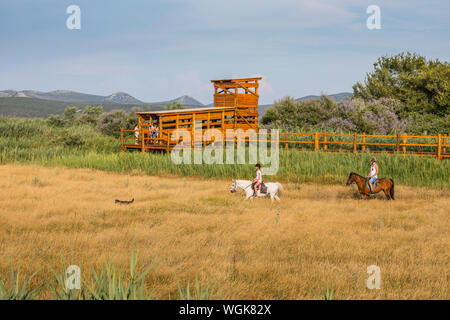 Touristen Reiten im Naturpark Vransko See in Kroatien. Birdwatching hölzernen Pfosten auf der Rückseite. Stockfoto