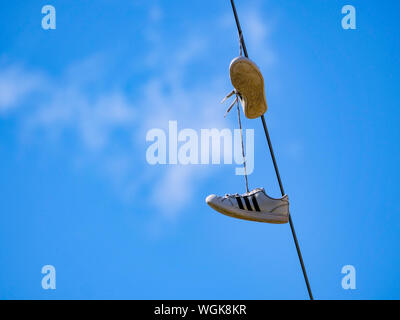 Sneakers hängen von Utility wire. Stockfoto