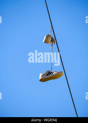 Sneakers hängen von Utility wire. Stockfoto