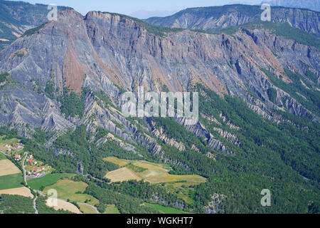 LUFTAUFNAHME. Landschaft von einem tief erodierten Berghang mit dem Weiler Rousset Fuß. Hautes-Alpes, Frankreich. Stockfoto