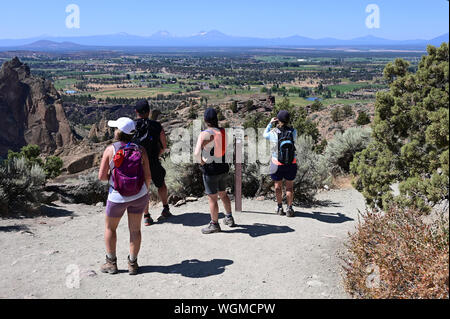 Wanderer auf Elend Ridge Trail in Smith Rock State Park in der Nähe von Terrebonne, Oregon an einem wolkenlosen Sommertag. Stockfoto