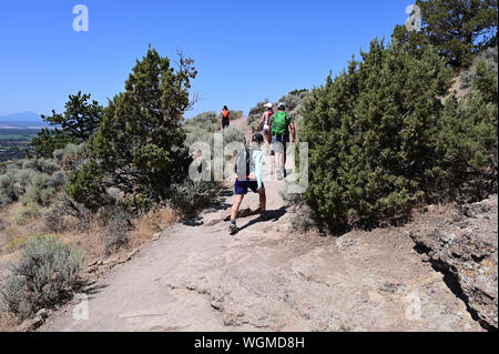 Wanderer auf Elend Ridge Trail in Smith Rock State Park in der Nähe von Terrebonne, Oregon an einem wolkenlosen Sommertag. Stockfoto