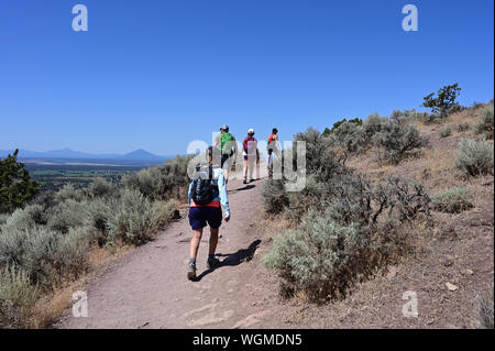 Wanderer auf Elend Ridge Trail in Smith Rock State Park in der Nähe von Terrebonne, Oregon an einem wolkenlosen Sommertag. Stockfoto