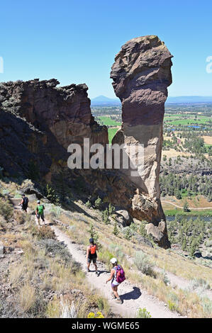 Wanderer auf Elend Ridge Trail in Smith Rock State Park in der Nähe von Terrebonne, Oregon an einem wolkenlosen Sommertag. Stockfoto