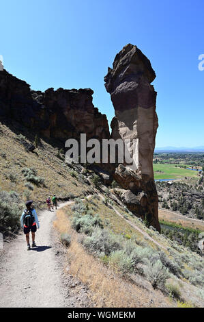 Wanderer auf Elend Ridge Trail in Smith Rock State Park in der Nähe von Terrebonne, Oregon an einem wolkenlosen Sommertag. Stockfoto