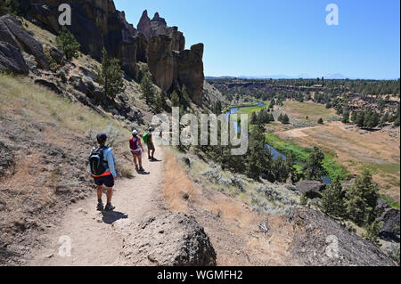 Wanderer auf Elend Ridge Trail in Smith Rock State Park in der Nähe von Terrebonne, Oregon an einem wolkenlosen Sommertag. Stockfoto