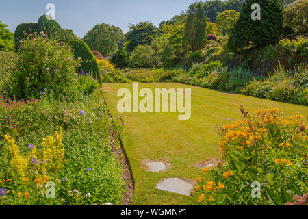 Gartenhaus Yelverton Devon UK, Landschaftsszene von Rasen, Blumenrändern und Eibenhecken Stockfoto