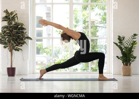 Schöne Frau stehen im Krieger eine Pose, yoga Virabhadrasana Übung Stockfoto