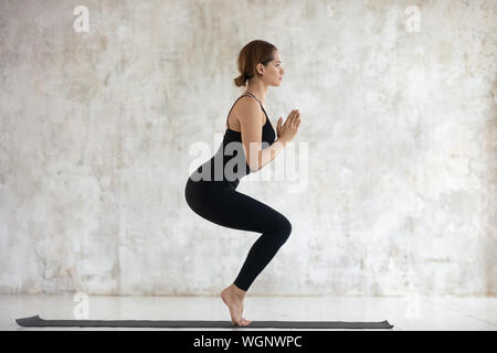 Junge Frau Üben Yoga, Stuhl, Utkatasana darstellen Stockfoto