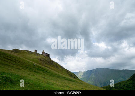 Gergeti Trinity Kirche oder Tsminda Sameba, dramatische landscaoe mit Wolken. Gergeti Kirche steht in der Nähe des Dorfes Gergeti in Georgien Stockfoto