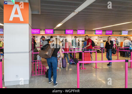 Warschau, Polen - Juli 2019: Wizz Air Check-in-Schalter und Passagiere am Flughafen Warschau Chopin warten. Wizz Air ist eine ungarische Billigfluggesellschaft Stockfoto