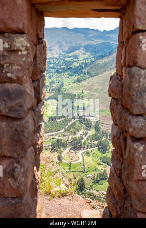 Pisac Stadt durch das Fenster der alten Inka Fort in den Ruinen von Pisac Stadt im Heiligen Tal, Cuzco, Peru Stockfoto