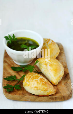 Empanadas mit chimichurri Sauce auf Holz kochen Board Stockfoto