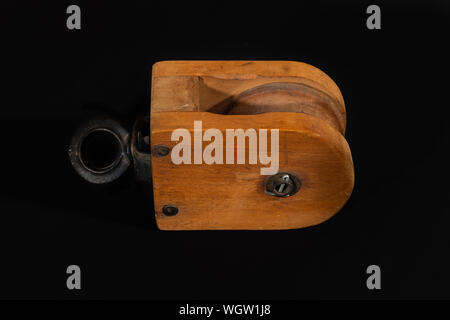 Vintage Holz- Riemenscheibe Block auf einem schwarzen Hintergrund isoliert. Stockfoto