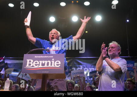 Portland, Maine, USA. 1. Sep 2019. September 1, 2019 - Portland, Maine. Ben Cohen, links, von Ben und Jerry's Ice Cream, springt vor Freude, als er verkündet US-Senator Bernie Sanders auf die Bühne für eine Kundgebung für den demokratischen Präsidentschaftskandidaten bei einem Stop an der Staatlichen Theater in Portland, Maine am Sonntag, 1. September 2019. Glücklich Neben Cohen ist Mitbegründer von Ben und Jerry's Ice Cream ist Jerry Greenfield. Quelle: Michael G. Seamans/ZUMA Draht/Alamy leben Nachrichten Stockfoto