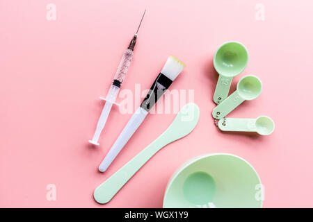 Tools und Injektor für zu Hause oder im Salon Gesichtspflege auf rosa Hintergrund, Ansicht von oben, flach. Serum, Maske. Mockup. Hautpflege Stockfoto