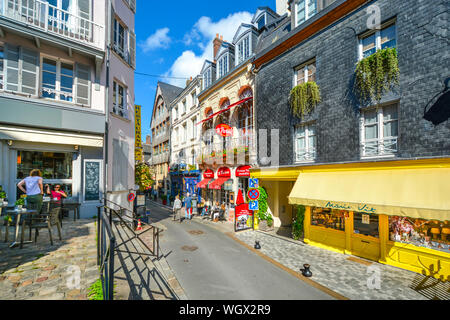 Touristen genießen die Straßencafés und bunten Geschäften in der küstenfischerei Dorf von Honfleur, Frankreich, an der Küste der Normandie. Stockfoto