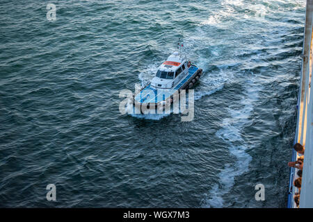Ancona, Italien - Juni 2019: Pilot Boot helfen ein Liner durch gefährliche Gewässer. Stockfoto