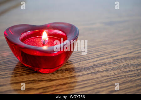 Herzform mit brennenden Kerze im Inneren. Valentinstag Konzept. Stockfoto