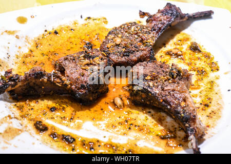 Gut Rib Eye Steak in schmierige weiße Platte getan. Das Steak mit Tender kochen ist gut gemacht und glitzert mit den Säften trocknen auf die weiße Platte. Stockfoto