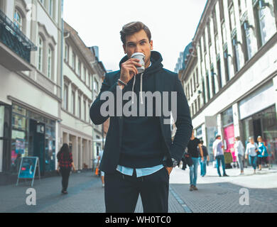 Junge Erwachsene schöne Attraktive stilvolle Geschäftsmann Gönnen Sie sich eine Pause und trinken Kaffee auf der Straße Stockfoto