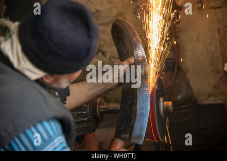 Man Schleifen auf abrasive schneiden und Messer Stockfoto