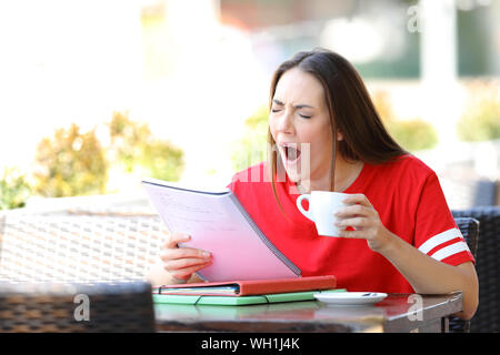 Müde Schüler Gähnen während studiert, sitzt in einem Café Terrasse Stockfoto