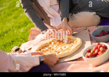 Zwei Studenten essen Pizza und Früchte, während dem Mittagessen Stockfoto