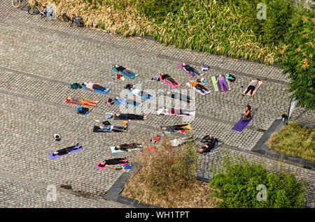 Rotterdam, Niederlande, 8. September 2018: Luftaufnahme des Yoga Klasse pracrticing Die savasana am Ende der Open air Lektion darstellen Stockfoto