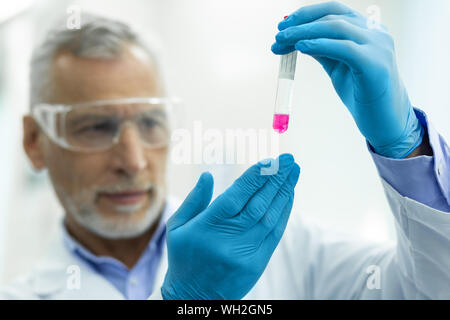 Im Mittelpunkt Foto auf männliche Hände, die Demonstration Reagenzglas Stockfoto
