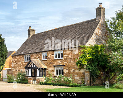 "Stoneleigh". Eine alte, hübsche, Eisenstein Ferienhaus mit Fachwerkhaus giebelhaus Veranda und Collyweston Schiefer Dach, Lyddington, Rutland, England, Großbritannien Stockfoto