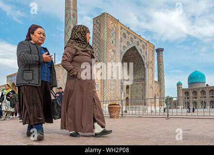 Usbekische Frauen vor ulugbek Medressa (ulugh Beg Madrasah), Registan Platz, Samarkand, Usbekistan Stockfoto