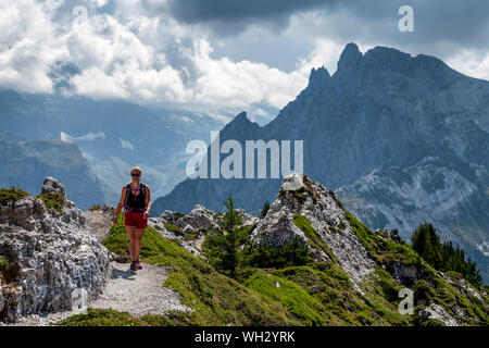 Eine Frau Wanderungen auf einem Ridge Trail in großer Höhe auf Dent du Villard in der Nähe von Courchevel in den Französischen Alpen. Stockfoto