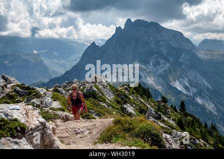 Eine Frau Wanderungen auf einem Ridge Trail in großer Höhe auf Dent du Villard in der Nähe von Courchevel in den Französischen Alpen. Stockfoto