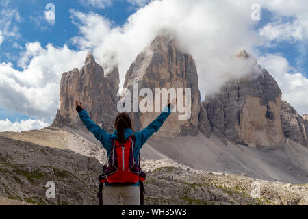 Mädchen mit Blick auf die beeindruckenden Drei Zinnen von Lavaredo, auf einem Rundweg zu Fuß rund um den obersten Spitzen Stockfoto