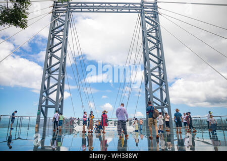 Yanoda, Hainan, China - 15.07.2019: Personen mit Panorama Brücke aus Glas in der Yanoda rain forest park auf der Insel Hainan in der Stadt Sanya, China Stockfoto