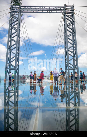 Yanoda, Hainan, China - 15.07.2019: Personen mit Panorama Brücke aus Glas in der Yanoda rain forest park auf der Insel Hainan in der Stadt Sanya, China Stockfoto