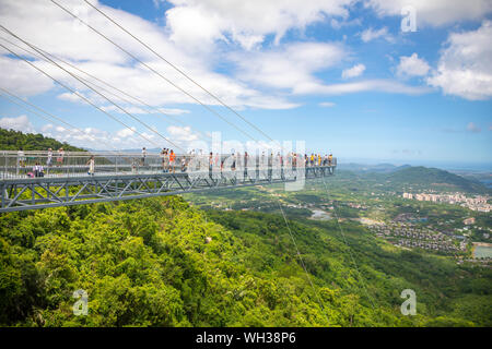 Yanoda, Hainan, China - 15.07.2019: Personen mit Panorama Brücke aus Glas in der Yanoda rain forest park auf der Insel Hainan in der Stadt Sanya, China Stockfoto