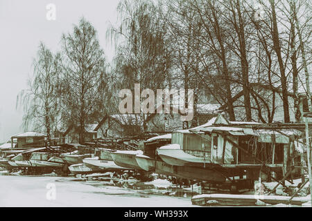 Einige alte und rostige sowjetischen Boote hängen auf Boot trap am Ufer eines Sees im Winter im Norden Europas. Stockfoto