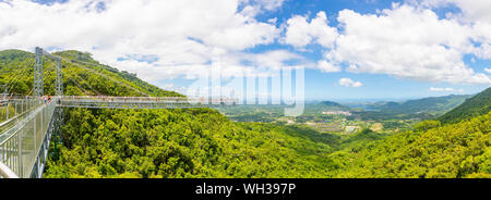 Yanoda, Hainan, China - 15.07.2019: Personen mit Panorama Brücke aus Glas in der Yanoda rain forest park auf der Insel Hainan in der Stadt Sanya, China Stockfoto