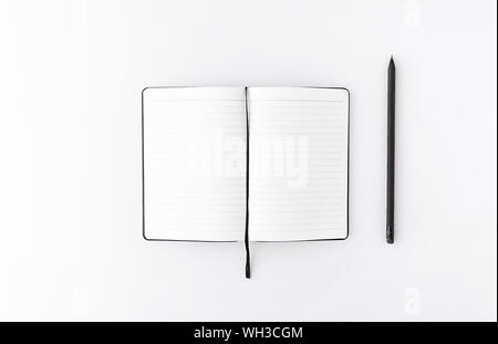 Ansicht von oben geöffnet Notepad mit schwarzen Bleistift weißen Hintergrund. Mockup für Ihr Design. Flach. Stockfoto