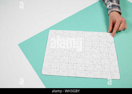 Hand das letzte Stück des Puzzles zur Vollendung der Aufgabe Stockfoto