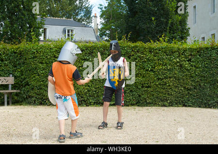 Kinder spielen mit Schwert und Schild und Helm auf Schloss d'Azay-le-Rideau im Loiretal in Frankreich Stockfoto