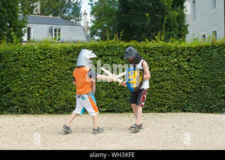 Kinder spielen mit Schwert und Schild und Helm auf Schloss d'Azay-le-Rideau im Loiretal in Frankreich Stockfoto