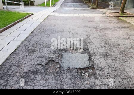 Beschädigte Straße in Göteborg, Schweden. Konzept für die Instandhaltung der Straßen. Stockfoto