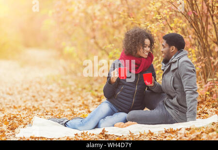 Junges Paar beim Picknick im Herbst Park, trinken Kaffee Stockfoto