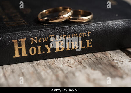 Die Bibel ist die Basis, wo auf zwei Trauringe Rest. Hochzeit Symbole, Attribute. Urlaub, Feiern. Stockfoto